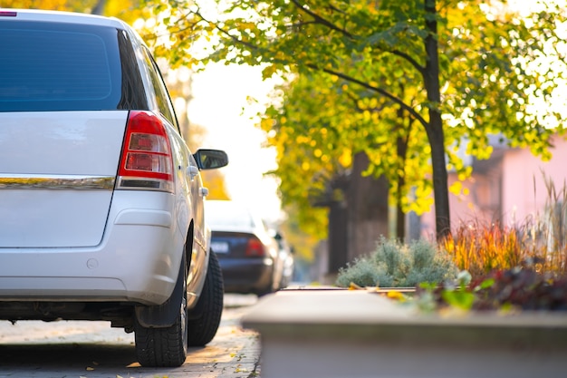 Carros estacionados em uma fileira em uma rua da cidade em um dia brilhante de outono.