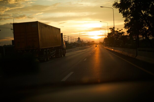 Foto carros na estrada contra o céu durante o pôr do sol