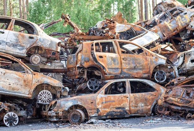 Carros queimados e enferrujados destruídos por explosões de foguetes Guerra na Ucrânia Veículos destruídos de civis que