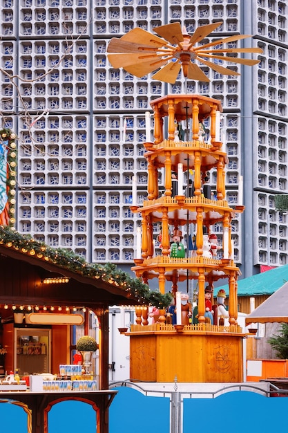 Foto carrossel de natal no mercado de natal na igreja memorial kaiser wilhelm em berlim de inverno, alemanha. decoração da feira do advento e barracas com artigos de artesanato no bazar.