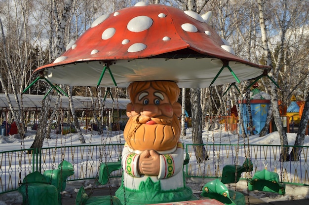 Carrossel em forma de cogumelo do velho avô no Parque das atrações cobertas