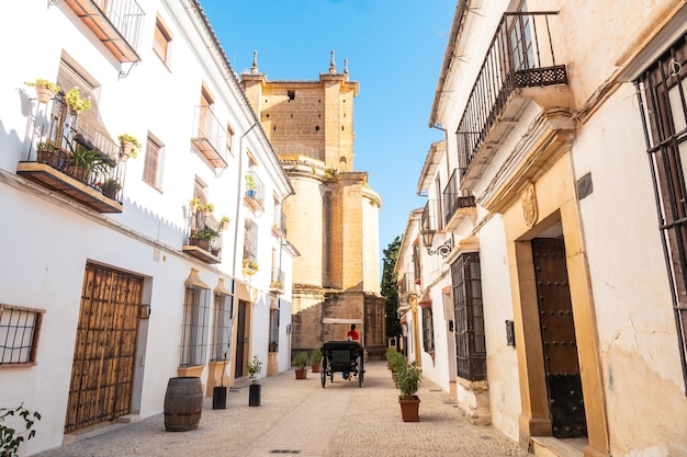 Carruagem com turistas ao lado da igreja de santa maria la mayor no centro histórico de ronda málaga