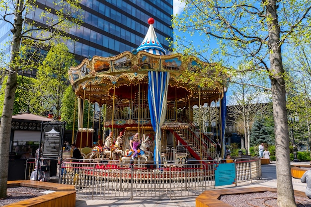 Un carrusel en un parque con un edificio al fondo