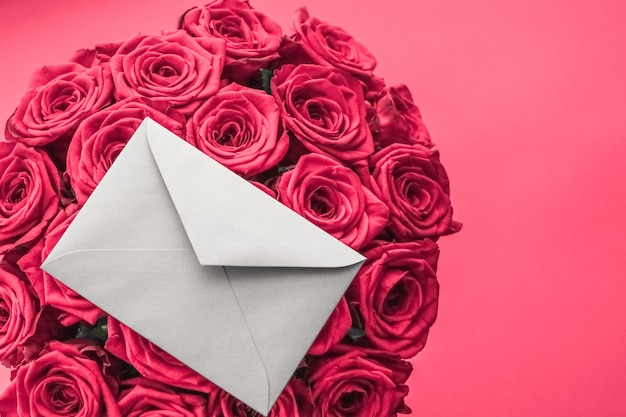 Carta de amor e entrega de flores no buquê de rosas de luxo do Dia dos Namorados e cartão em fundo rosa para design de férias românticas