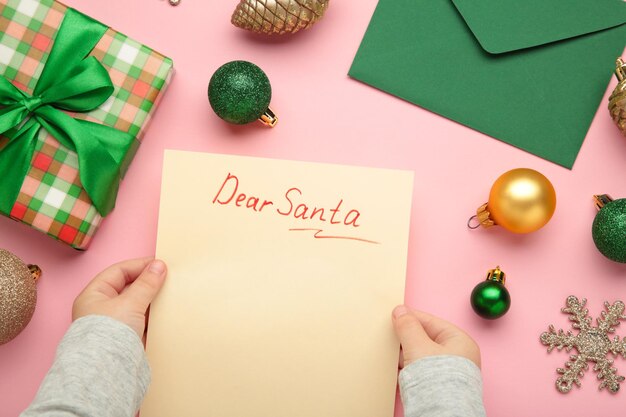 Carta de Navidad de un niño a Papá Noel con las palabras Querido Papá Noel composición con bolas amarillas y verdes Vista superior