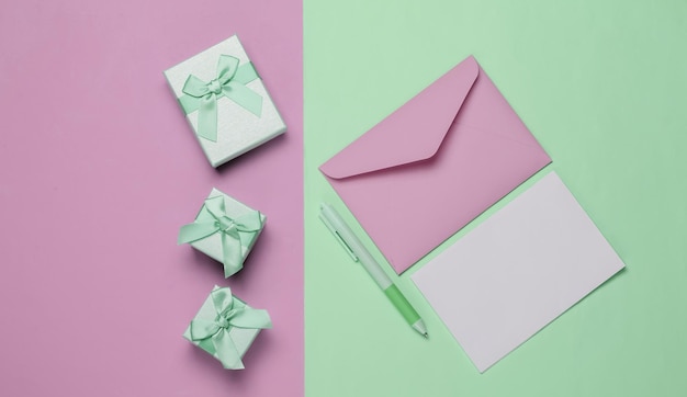 Carta para o envelope do papai noel com caixas de cartas e canetas de presentes em fundo verde rosa vista superior plana de natal
