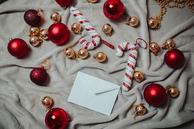 Carta a Santa Plana con bolas rojas de Navidad, bolas de Navidad doradas y bastones de caramelo de Navidad en la tela escocesa.