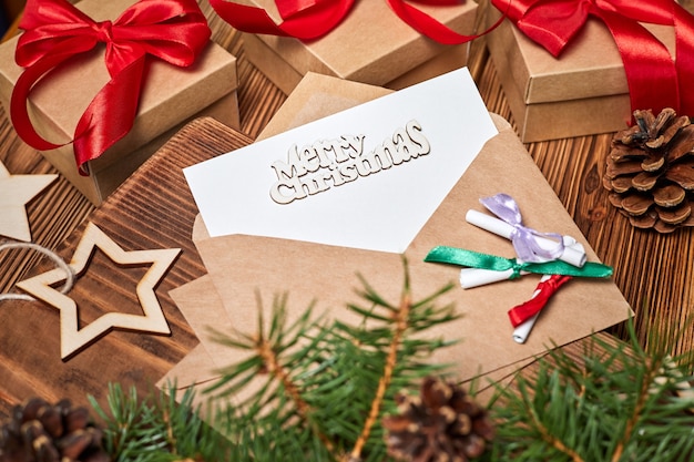 Carta en un sobre con la inscripción feliz navidad en el fondo de cajas de regalo de Navidad