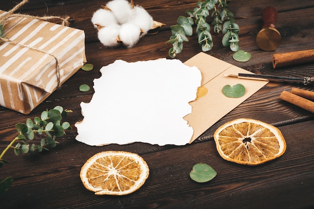 Carta vacía con una pluma sobre fondo de madera vieja decorada con objetos de navidad