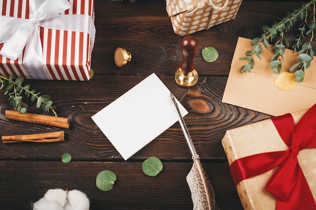 Carta vazia com uma pena na velha de madeira decorada com objetos de Natal