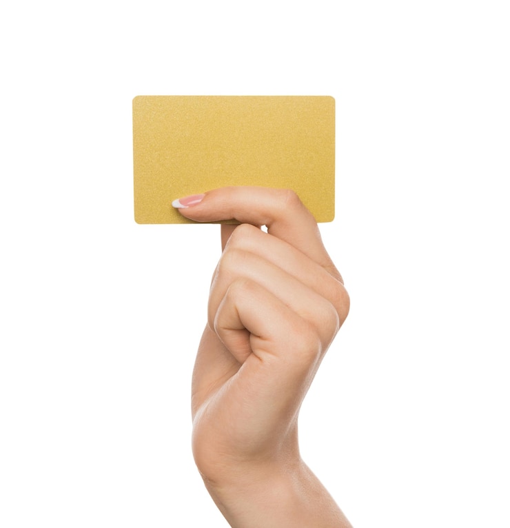 Foto cartão amarelo. mão feminina com manicure francesa segurando crédito de plástico, mulher mantendo cartão de visita em branco no fundo branco do estúdio isolado, espaço de cópia, recorte