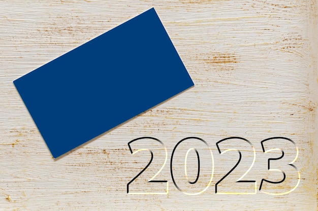 Cartão azul na mesa de pátina com 2023 ano novo ano