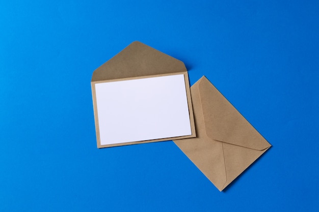 Cartão branco em branco com kraft papel marrom envelope modelo simulado acima