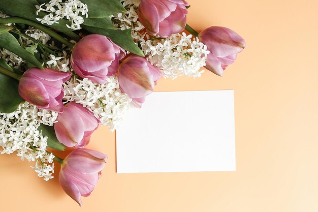 Cartão branco em branco e buquê de primavera em um fundo amarelo Mock up cartão de papel branco em branco para texto