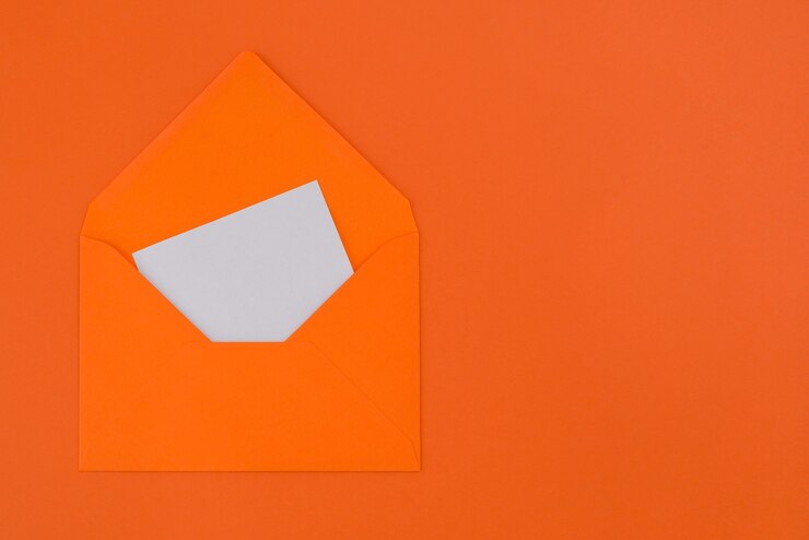 Foto cartão branco em branco em envelope laranja isolado em fundo laranja pastel com espaço de cópia.