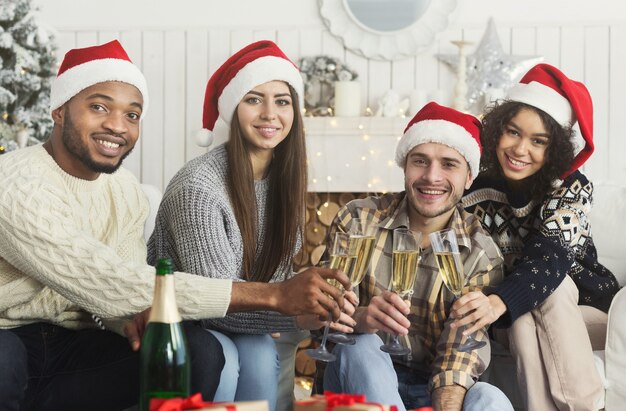 Cartão de ano novo. Amigos felizes a tilintar de taças com champanhe, copie o espaço