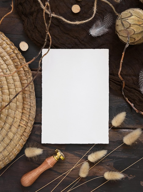 Foto cartão de convite em branco em mesa de madeira castanha escura com decorações boêmias