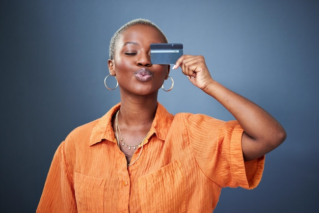 Cartão de crédito de compras e mulher negra no estúdio para poupança bancária e orçamento em fundo cinza Cashback de investimento e mulher africana satisfeita com o pagamento da associação ou experiência do cliente