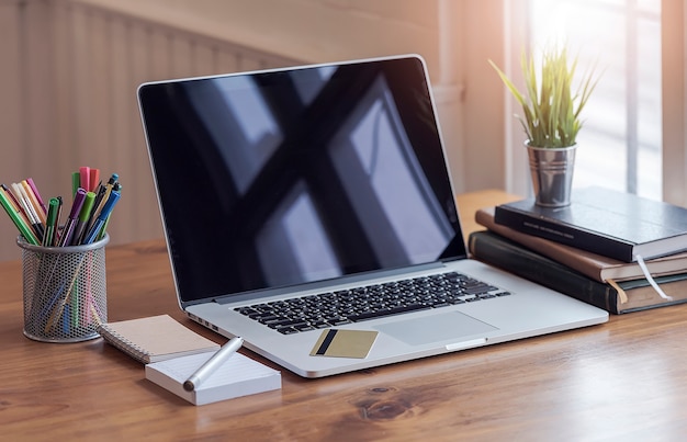 Cartão de crédito e laptop na mesa de madeira dentro de casa