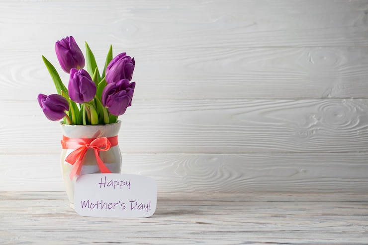 Foto cartão de dia das mães feriado com um buquê de tulipas roxas frescas em um vaso com um laço rosa