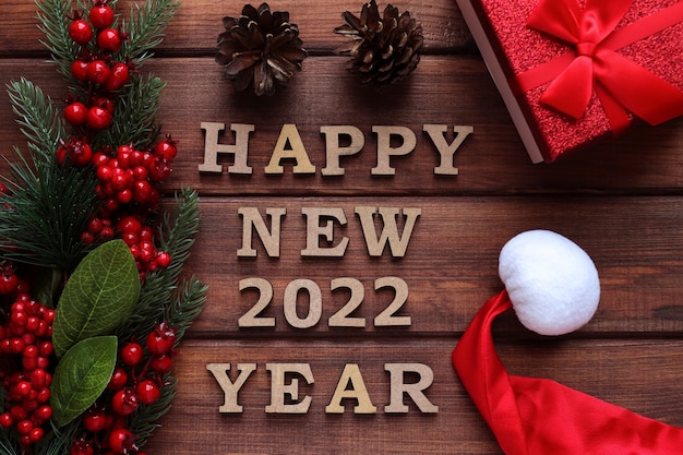 Cartão de felicitações de ano novo inscrição feliz ano novo com ramos de abeto pinhas e caixa de presente