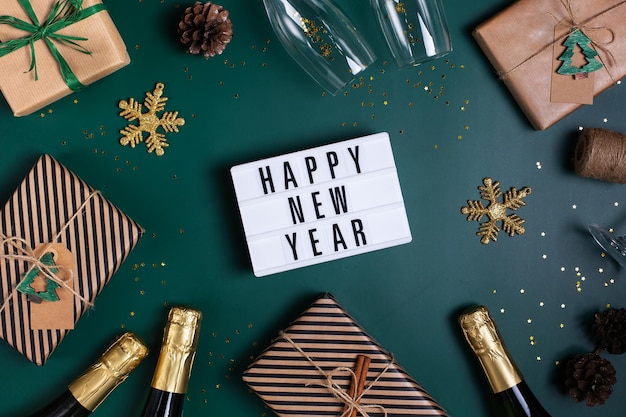 Cartão de feliz ano novo com champanhe e caixas de presente