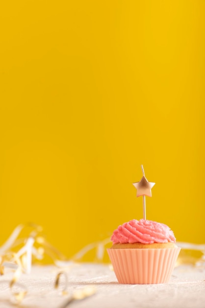 Cartão de férias com bolinho com velas em fundo amarelo brilhante e lugar para o seu texto. Moldura vertical