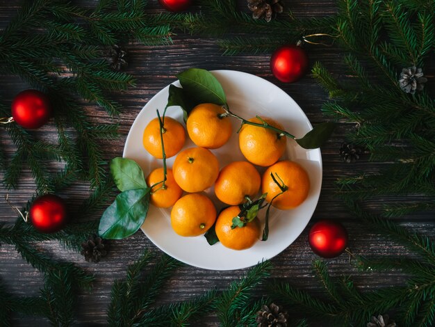 Cartão de férias de Natal com tangerinas e ramos de abeto e pinhas