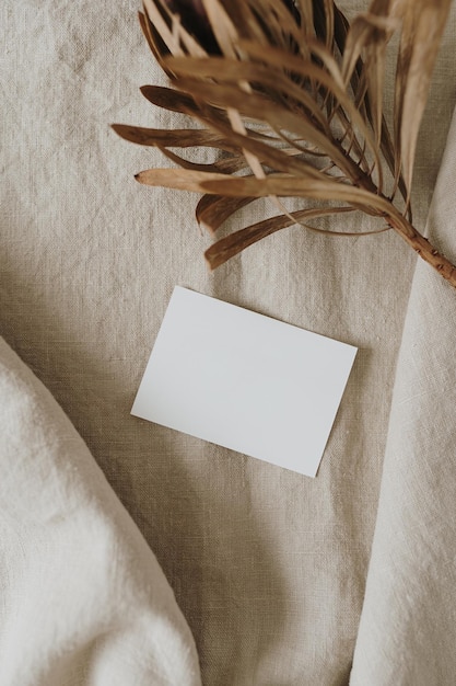 Cartão de folha de papel em branco com espaço de cópia de maquete flor de protea seca em cobertor de linho bege neutro Modelo de marca de negócios estético mínimo Vista superior plana