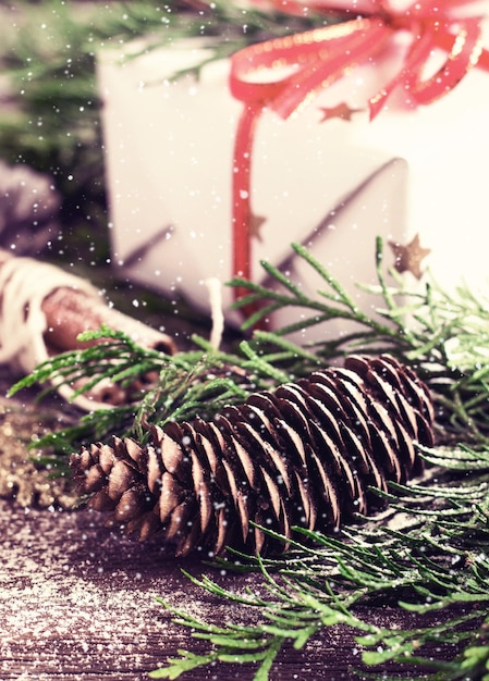 Cartão de natal com caixa de presente de feriado e cone de coníferas Snowin