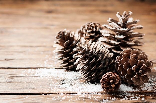 Cartão de Natal com cones na mesa de madeira