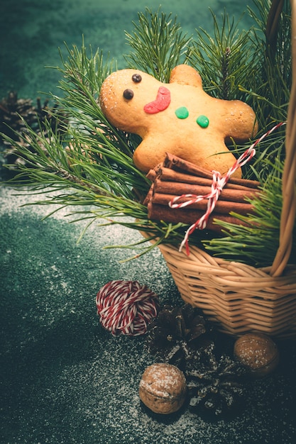 Cartão de Natal com homem-biscoito e galhos de coníferas na cesta