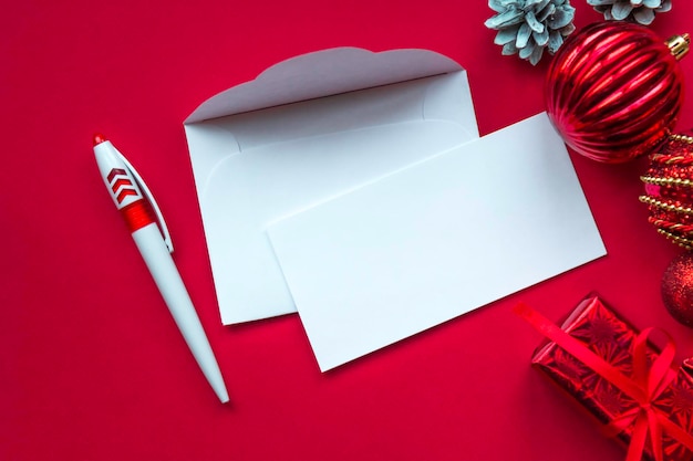 Cartão de natal em branco e decorações de natal em fundo vermelho. postura plana, espaço coppy. carta de natal para o conceito de papai noel.