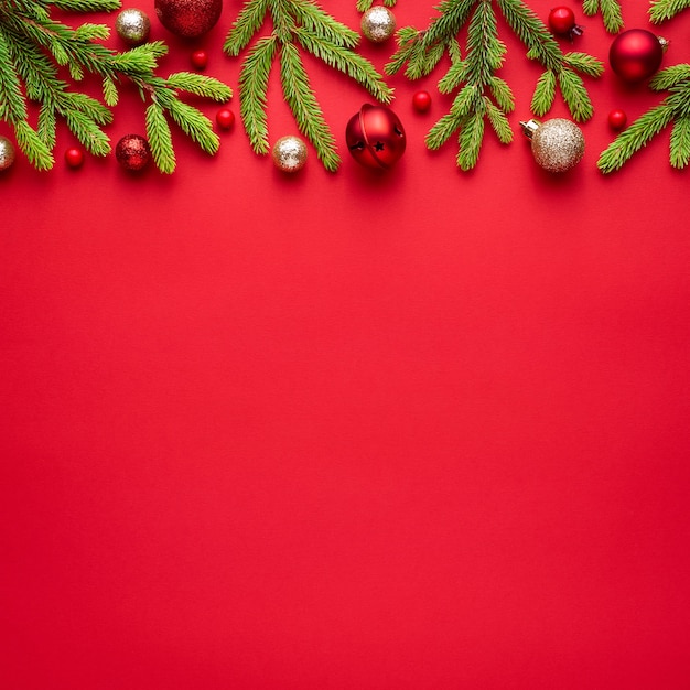 Cartão de Natal quadrado com decorações de abeto em fundo vermelho / em branco com espaço de cópia para texto publicitário. Vista superior, configuração plana