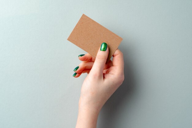Cartão de papel ofício na mão feminina isolado no branco