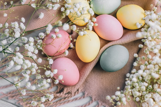 Cartão de Páscoa feliz com ovos multicoloridos e flores em tons pastel.