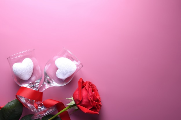 Cartão de plano de fundo dia dos namorados amor símbolos, decoração vermelha com óculos no fundo rosa. Vista superior com cópia espaço e texto.
