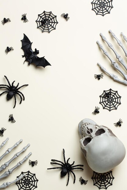 Cartão de saudação de halloween com crânios de abóbora, mãos ósseas e folhas.
