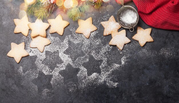 Cartão de saudação de Natal com abeto e biscoitos de pão de gengibre em fundo de pedra Vista superior plana com espaço para suas saudações de Natal