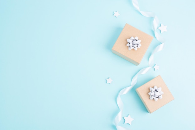 Cartão de saudação de Natal com pequenas caixas de presentes estrelas e galhos de abeto fundo azul