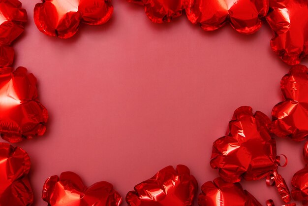 Cartão de saudação em branco do Dia dos Namorados de balões de folha em forma de coração em fundo vermelho com espaço de cópia