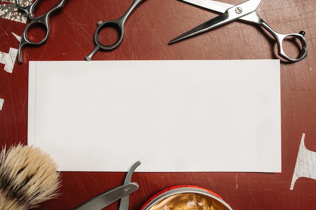 Foto cartão em branco com ferramentas de barbeiro na mesa