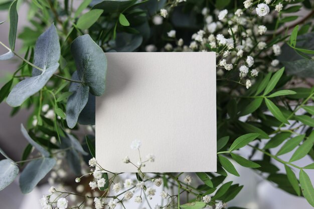 cartão em branco em cima de um buquê de flores de casamento
