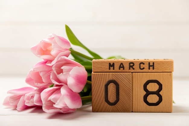 Cartão festivo com tulipas cor de rosa para 8 de março.