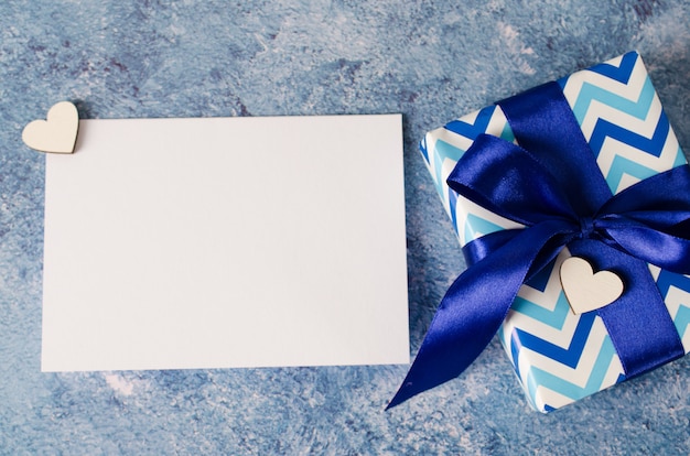 Cartão para dia dos pais ou aniversário. caixa de presente com papel branco em branco sobre fundo azul.