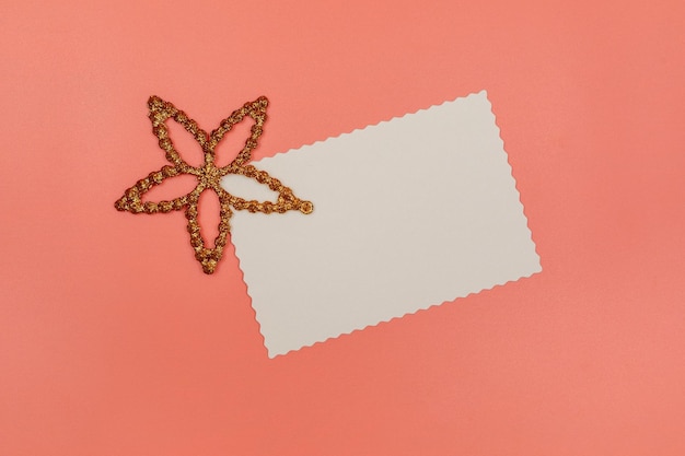 Cartão postal branco em branco e estrela de decoração em fundo rosa Natal, Ano Novo, Dia dos Namorados