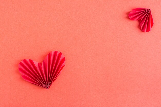 Cartão postal com corações de origami Fundo monocromático vermelho Copie o espaço