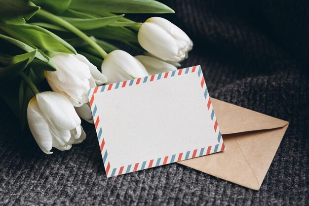 Cartão postal em branco e buquê de flores de tulipas brancas frescas
