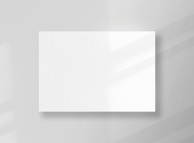 Cartão quadrado em branco, folha como maquete com sombras ensolaradas na superfície cinza
