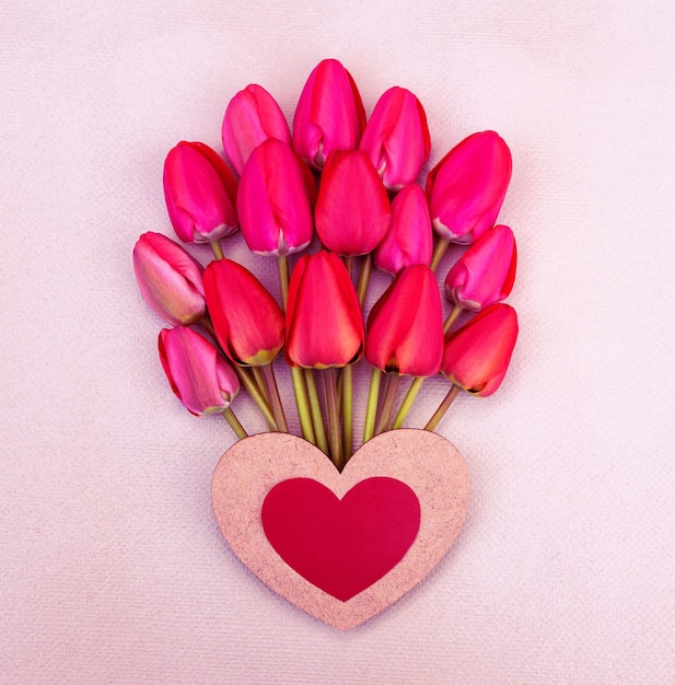 Cartão romântico com um grande buquê de tulipas macias vermelhas brilhantes